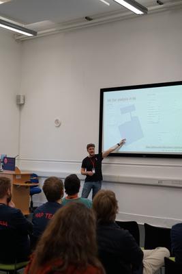 A speaker points to their slide in the 'node' room