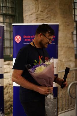 Gregory accepts flowers as a thank you for leading the conference organisation.