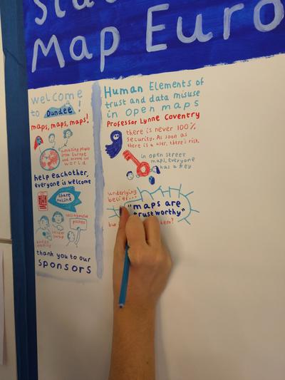 Live-drawn map of the conference, with Cara Rooney working on documenting the second talk. Photo by Gregory Marler