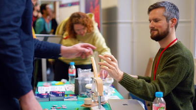 A freshly-made badge is passed to a delegate