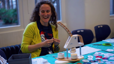 Anna enjoying making badges for delegates